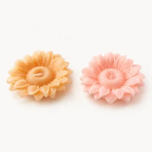 Deux bougies en forme de marguerite, orange et rose