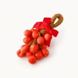 Bougie en forme de grappe de baies rouges avec nœud en satin